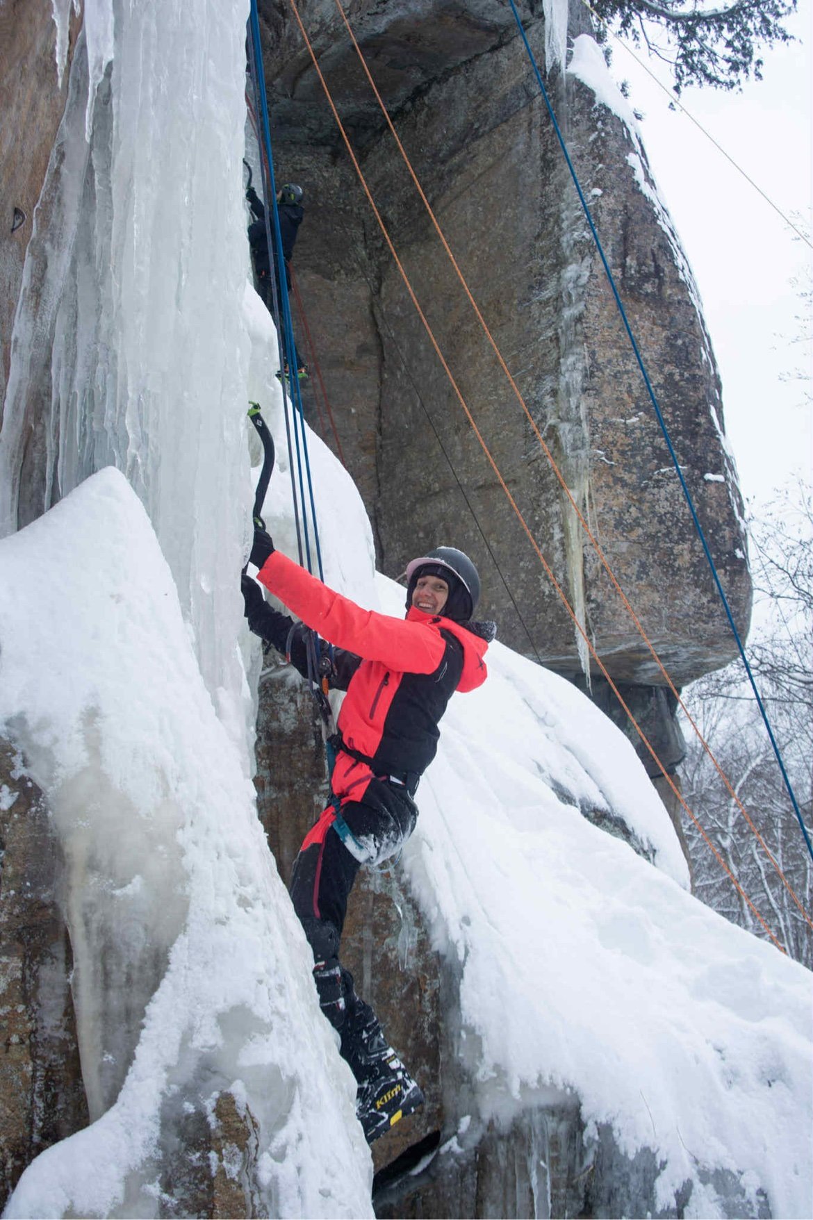 Ollie en escalade de glace, piolet en main sur une paroi gelée